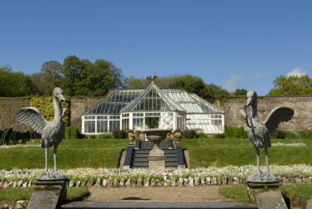 A view of the conservatory against the back wall of the Victorian garden at Arlington Court, Devon.