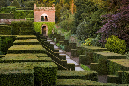 View over the compartmentalised hedging of the Dahlia Walk towards the Shelter House at Biddulph Grange Garden, Staffordshire.