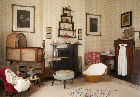 The Day Nursery with a mahogany and wicker cradle and a collection of Victorian toys at Arlington Court, Devon