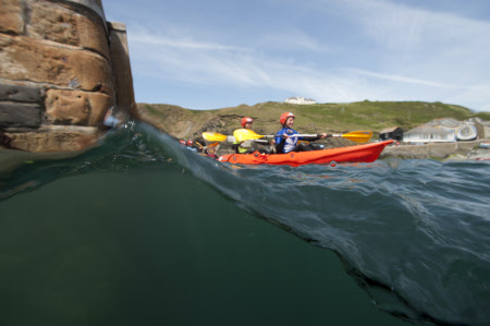 People kayaking at Mullion Cove, Cornwall.